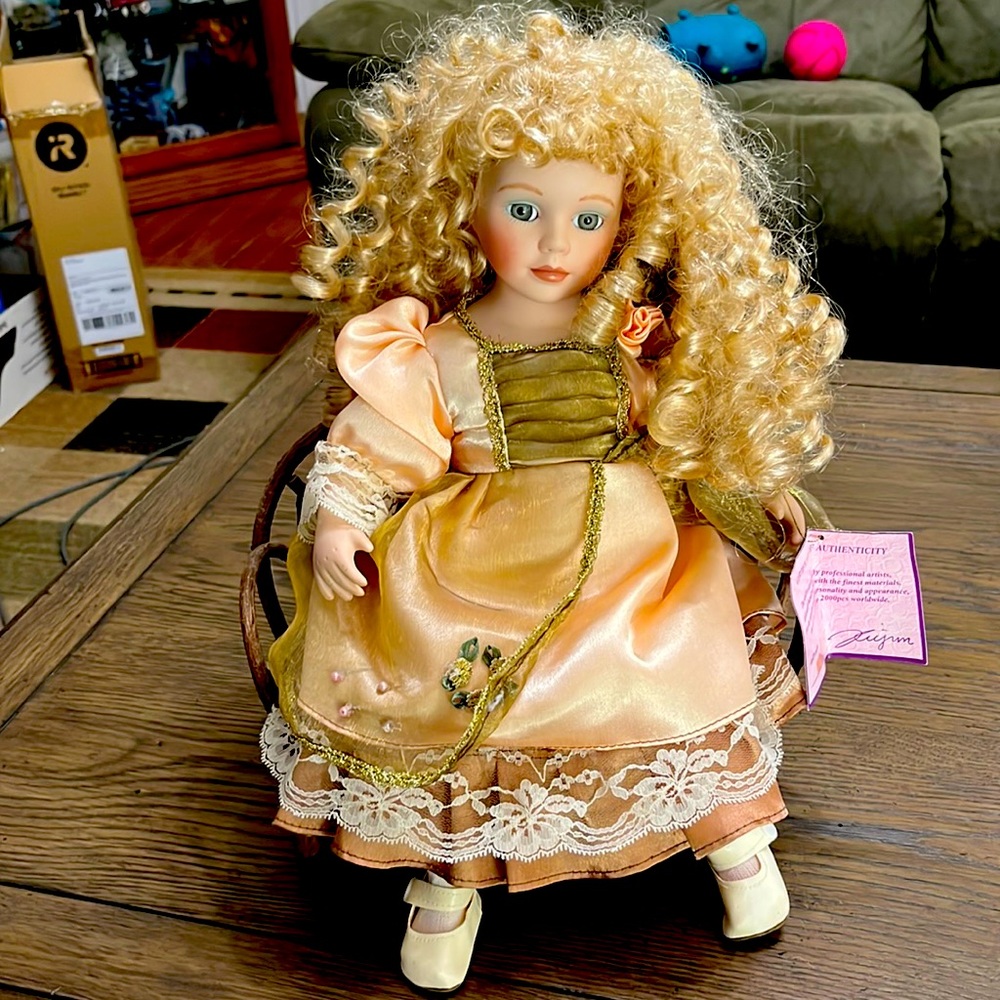Sitting porcelain doll with wooden bench